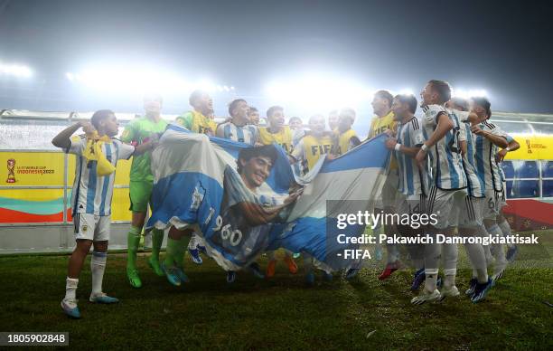 Players of Argentina celebrate with a banner of Diego Maradona following the team's victory in the FIFA U-17 World Cup Round of 16 match between...