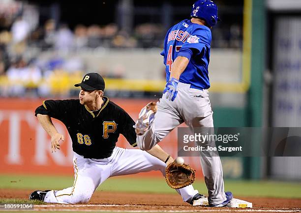 Brian Bogusevic of the Chicago Cubs is safe at first base in front of Justin Morneau of the Pittsburgh Pirates on September 14, 2013 at PNC Park in...