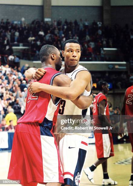 University of Connecticut basketball player Caron Butler, right, hugs an opposing player as he celebrates a win against St. John's University, in...