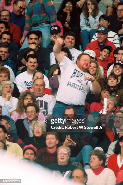 The University of Connecticut men's basketball team's number one fan, a bearded figure known as 'Big Red', leads the crowd in a cheer, Storrs,...