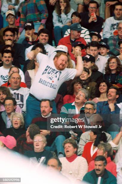 The University of Connecticut men's basketball team's number one fan, a bearded figure known as 'Big Red', leads the crowd in a cheer, Storrs,...