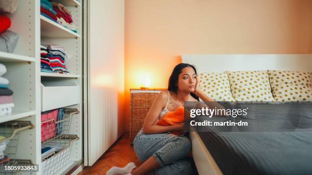 mujer con dolor de estómago quedándose en casa - ciclo de menstruación fotografías e imágenes de stock