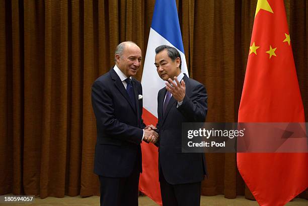 French Foreign Minister Laurent Fabius shakes hands with Chinese Foreign Minister Wang Yi before their meeting at the Chinese Foreign Ministry on...