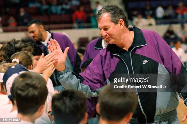 UConn's Jim Calhoun high fives young fans on the sidelines of his basketball clinic, Hartford, Connecticut, 1994.