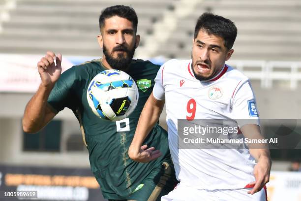 Mamoon Moosa Khan of Pakistan and Rustam Soirov of Tajikistan aiming towards the ball during the 2026 FIFA World Cup AFC Qualifier Group G match...