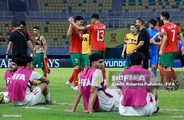 Players of IR Iran look dejected as players of Morocco celebrate after the penalty shootout in the FIFA U-17 World Cup Round of 16 match between...