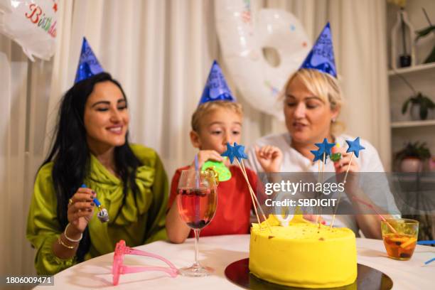 happy caucasian boy celebrating his 6th birthday with his mothers - godmother stock pictures, royalty-free photos & images