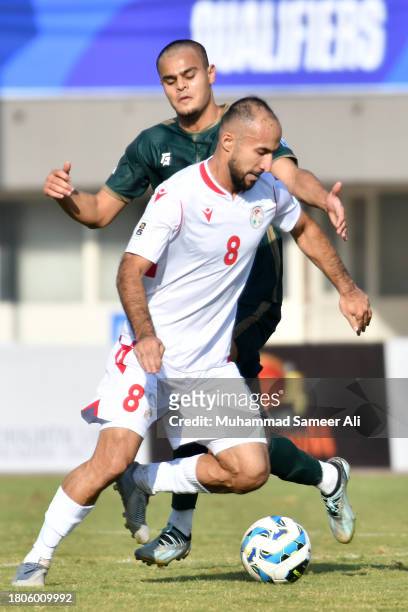 Amirbek Juraboev from Tajikistan defends the ball from Abdul Samad of Pakistan during the 2026 FIFA World Cup AFC Qualifier Group G match between...