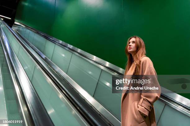 confident young woman using escalators in the subway - rise from the grave stock pictures, royalty-free photos & images