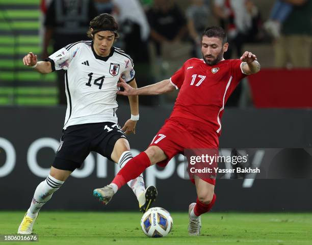 Junya Ito of Japan battles for possession with Fahad Youssef of Syria during the FIFA World Cup Asian 2nd qualifier match between Syria and Japan at...