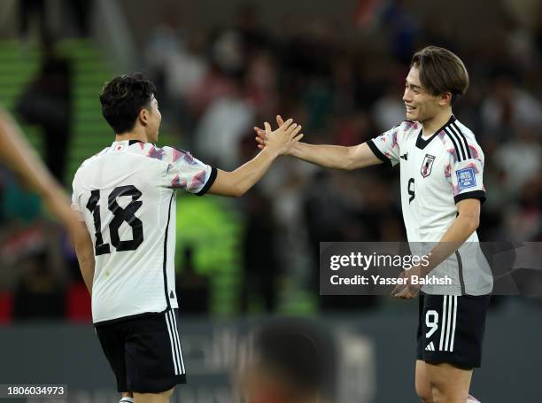 Ayase Ueda of Japan celebrates with Takuma Asano after scoring the team's second goal during the FIFA World Cup Asian 2nd qualifier match between...
