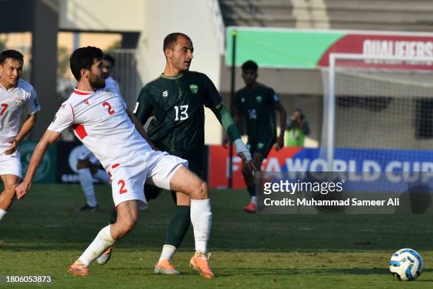 Zoir Dzhurabeov from Tajikistan passes the ball before Fareed Ullah from Pakistan reaches him during the 2026 FIFA World Cup AFC Qualifier Group G...