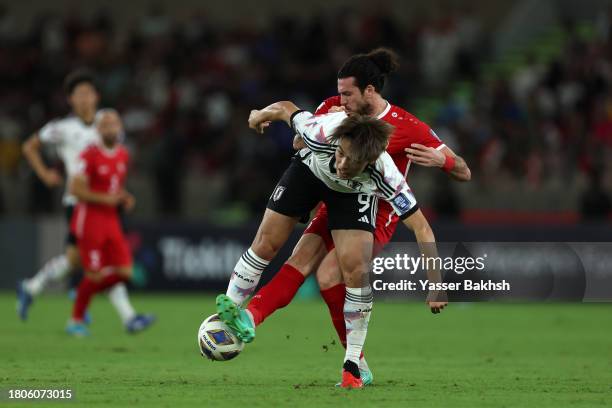 Ayase Ueda of Japan battles for possession with Omro Al Midani of Syria during the FIFA World Cup Asian 2nd qualifier match between Syria and Japan...