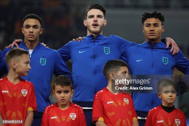 Trent Alexander-Arnold, Declan Rice and Ollie Watkins of England sing their national anthem prior to the UEFA EURO 2024 European qualifier match...