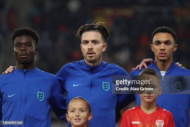 Bukayo Saka, Jack Grealish and Trent Alexander-Arnold of England sing their national anthem prior to the UEFA EURO 2024 European qualifier match...