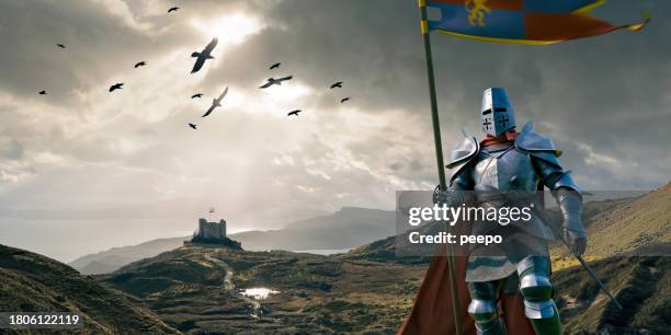 chevalier médiéval debout tenant un drapeau de bannière près du château - chevalier photos et images de collection