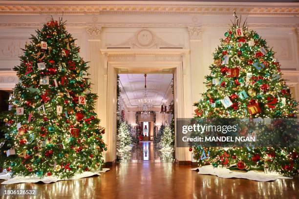 Christmas trees are seen in the East Room looking towards the Cross Hall during the media preview for the 2023 Holidays at the White House in...