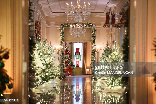 Christmas trees are seen in the East Room looking towards the Cross Hall during the media preview for the 2023 Holidays at the White House in...