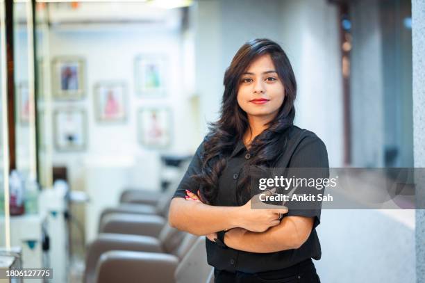 portrait of female hairdresser at the salon holding hairdressing scissor - beauty salon stock pictures, royalty-free photos & images