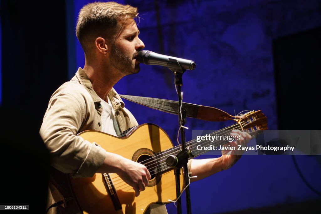 Singer playing guitar and singing on stage during a concert