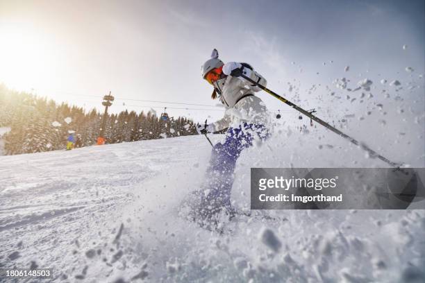 teenage girl skiing in mountains of european alps in austria - skiing and snowboarding stock pictures, royalty-free photos & images