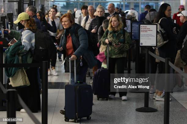 Passengers wait in-line for going through security check at Ronald Reagan Washington National Airport on November 21, 2023 in Arlington, Virginia....