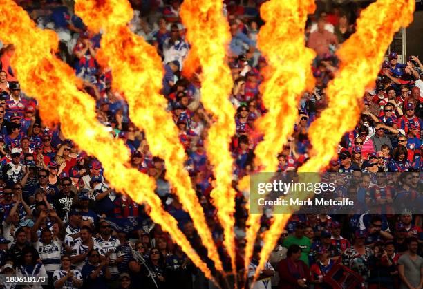 Fans are seen through flames during the NRL Elimination Final match between the Canterbury Bulldogs and the Newcastle Knights at ANZ Stadium on...