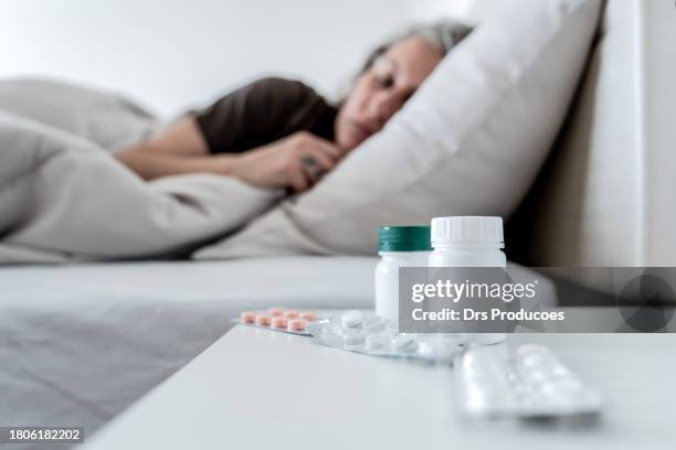 depressed woman lying in her bed - slaappil stockfoto's en -beelden
