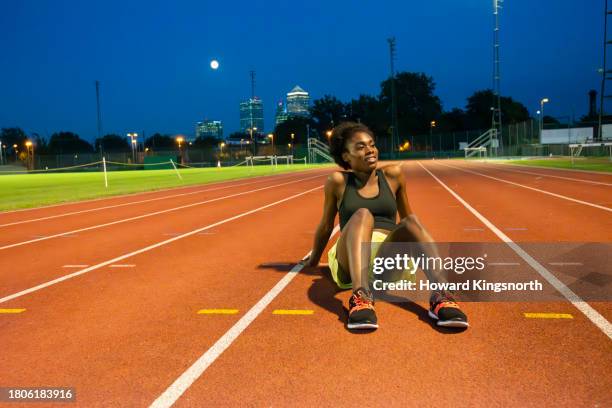 female athlete on empty running track - active seniors running stock pictures, royalty-free photos & images