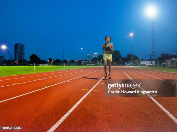 female athlete on empty running track - active seniors running stock pictures, royalty-free photos & images