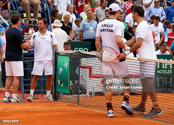 Andy Murray of Great Britain is congratulated by Ivan Dodig of Croatia as Captain's Leon Smith of Great Britain and Zeljko Krajan of Croatia meets...