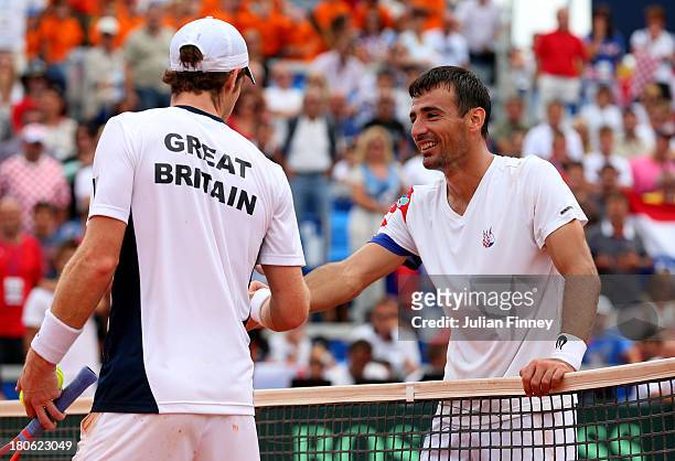 Andy Murray of Great Britain and Ivan Dodig of Croatia disscuss a line call during day three of the Davis Cup World Group play-off tie between...