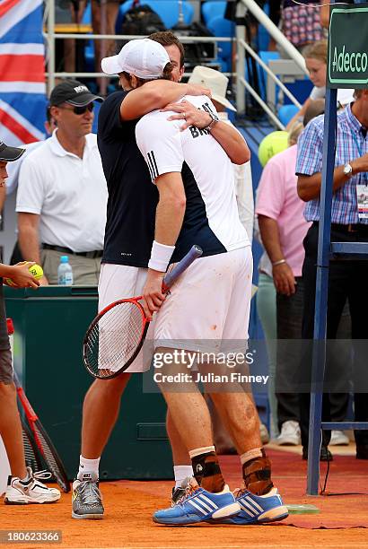 Andy Murray of Great Britain is congratulated by team captain Leon Smith mates after winning against Ivan Dodig of Croatia during day three of the...