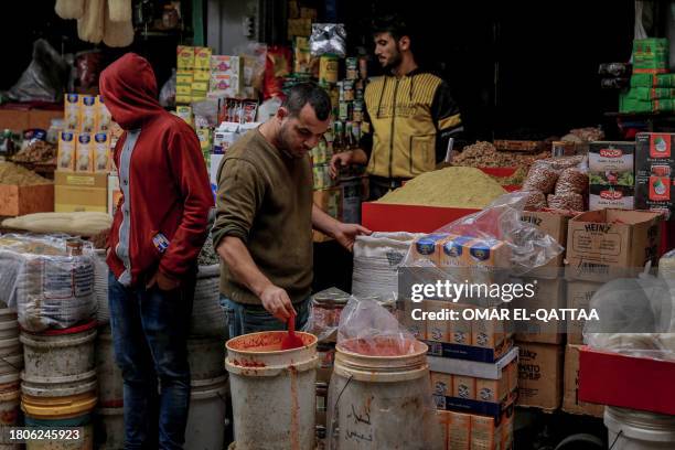 Palestinians open their store for shoppers at Al-Zawiya market in Gaza City on November 27 on the fourth day of a truce in fighting between Israel...