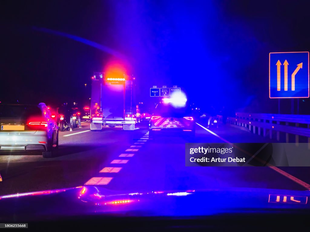 Car accident at night with the police and firefighter with emergency lights.