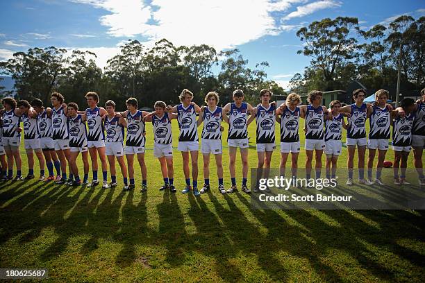 Warburton Millgrove players stand for the Australian national anthem before the start of the Yarra Valley Mountain District Football League Under 18...