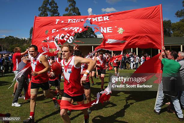 Healesville players run through their team banner during the Yarra Valley Mountain District Football League Division 2 Reserves Grand Final between...