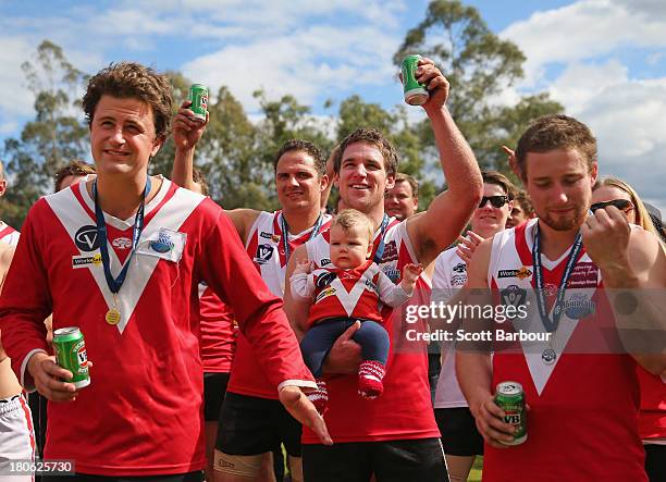 Healesville players celebrate with a beer as they watch the presentations before being presented with the premiership flag and trophy after winning...