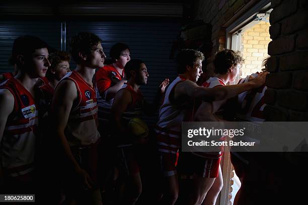 Olinda Ferny Creek players leave their changing room to run onto the field for the start of the Yarra Valley Mountain District Football League Under...