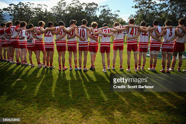 Olinda Ferny Creek players stand for the Australian national anthem before the start of the Yarra Valley Mountain District Football League Under 18...