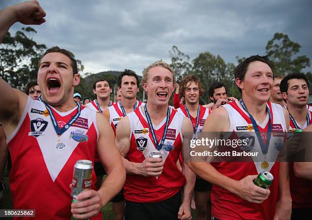 Healesville players celebrate with a beer as they watch the presentations before being presented with the premiership flag and trophy after winning...