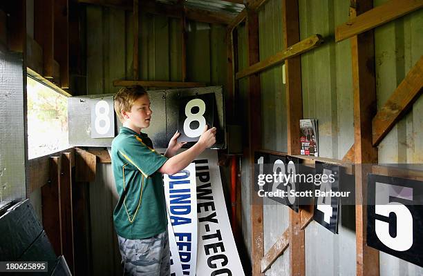 The scoreboard attendant changes the score inside of the scoreboard during the Yarra Valley Mountain District Football League Division 2 Reserves...