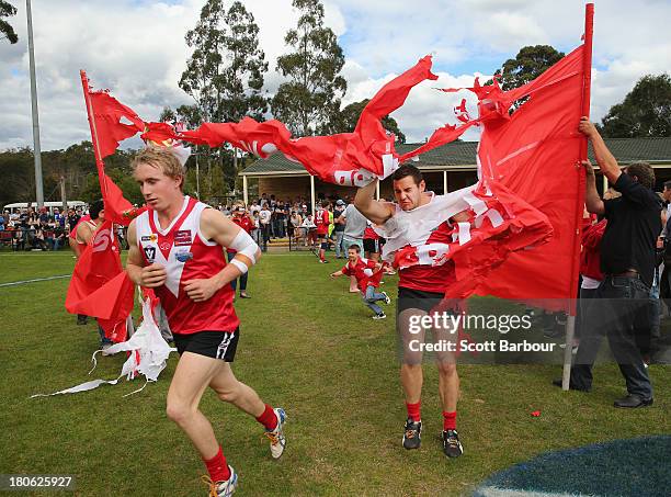 Healesville player gets caught in the banner as the team run through their team banner during the Yarra Valley Mountain District Football League...