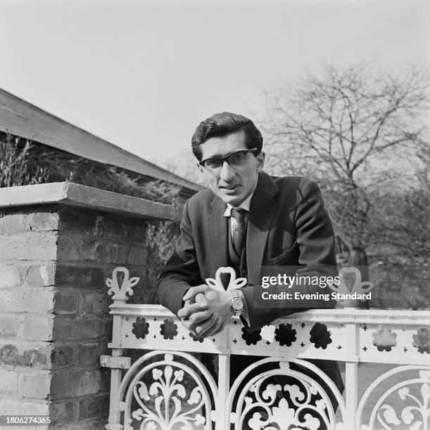 Pratap Chitnis leaning on an iron gate, February 15th 1962. Chitnis was the agent for Eric Lubbock during the Liberal campaign in the Orpington...
