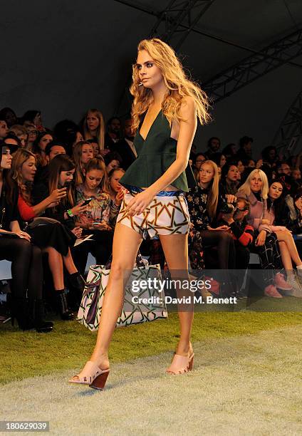 Cara Delevingne walks the runway at the Unique SS14 runway show during London Fashion Week on September 15, 2013 in London, England.