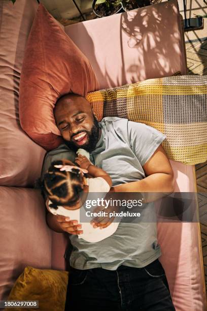 a devoted stay at home dad enjoying a restful moment with his baby girl - stay at home father stock pictures, royalty-free photos & images