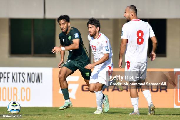 Imran Shahid Kayani of Pakistan and Ehson Panshanbe of Tajikistan run after the ball during the 2026 FIFA World Cup AFC Qualifier Group G match...