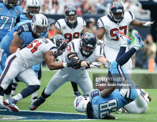 Chris Johnson of the Tennessee Titans is tackled by a group of Houston Texans at Reliant Stadium on September 15, 2013 in Houston, Texas.