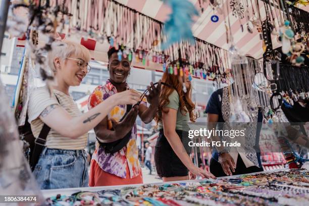 des amis achètent des souvenirs au marché de rue - boutique de souvenirs photos et images de collection