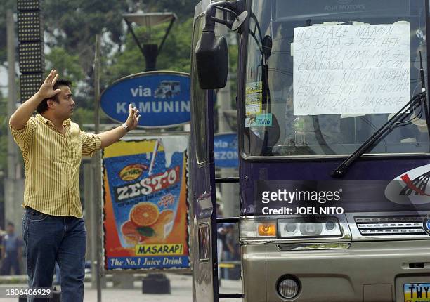Action movie star and Senator Ramon Revilla stands next to the bus as he negotiates for the release of a boy suffering from fever during a hostage...